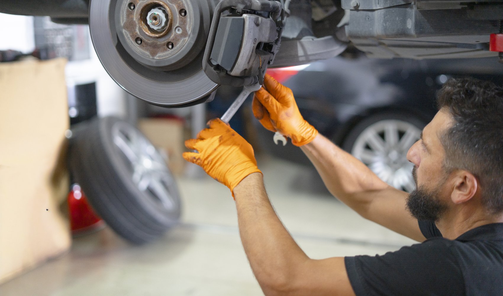 Mechanic changing car brake pads in workshop